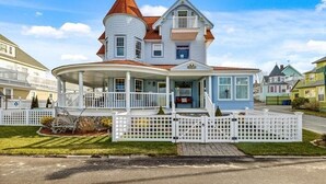 A large, two-story house with a wrap-around porch and a turret. - BELLE of the BEACH: 30 ft to gorgeous PRIVATE BEACHFRONT home SLEEPS up to 13 (Wareham)