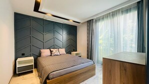 A modern bedroom with a bed, nightstands, and a wooden desk. - Villa mit Privatem Pool in der Nähe von Strand und Einkaufszentrum (Kuşadası)