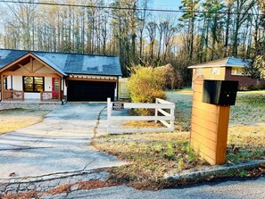 Ein privates Anwesen mit Garage, Holzbriefkasten und einem eingenetzten Eingang.