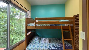 A bunk bed room with a window, a teal wall, and a wooden ladder. - The Spot @ Cocles #1 (Cocles)