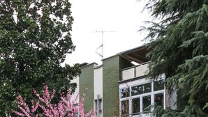 A residential building with a green facade, multiple windows, and a balcony. - Flytosuite aeroporto attico mansarda  (Calderara di Reno)
