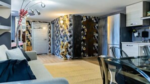 A modern living room with a sofa, a glass coffee table, and a decorative plant. - Flytosuite aeroporto attico mansarda  (Calderara di Reno)