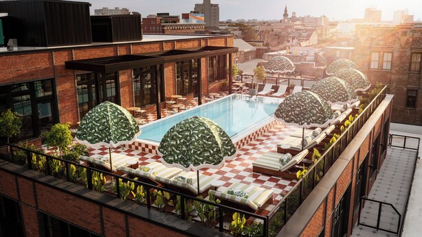 Un espace piscine aménagé sur le toit, avec un sol à carreaux, des chaises longues et des parasols.
