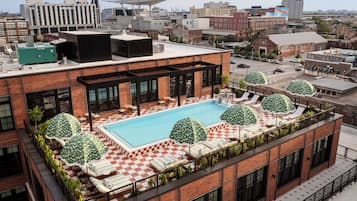 Relax on the rooftop terrace with a refreshing dip in the pool surrounded by lounge chairs and umbrellas.