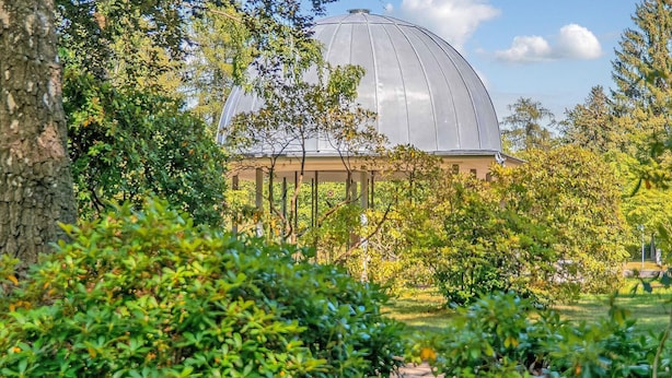 A large, modern building with a dome structure surrounded by lush greenery. - Ferienwohnung Friedrichroda (Friedrichroda)