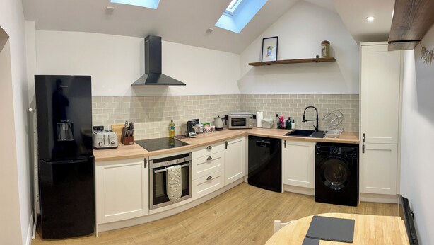 A modern kitchen with a black refrigerator, a microwave, a toaster, and a sink. - Blackberry Cottage - Cosy Autumn Getaway in Cardiff

 (Cardiff)