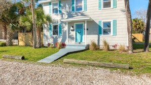 A two-story house with a front porch, palm trees, and a gravel driveway. - Lower · 2/1 - Lower Unit - 4 Blocks to the Beach (Jacksonville Beach)