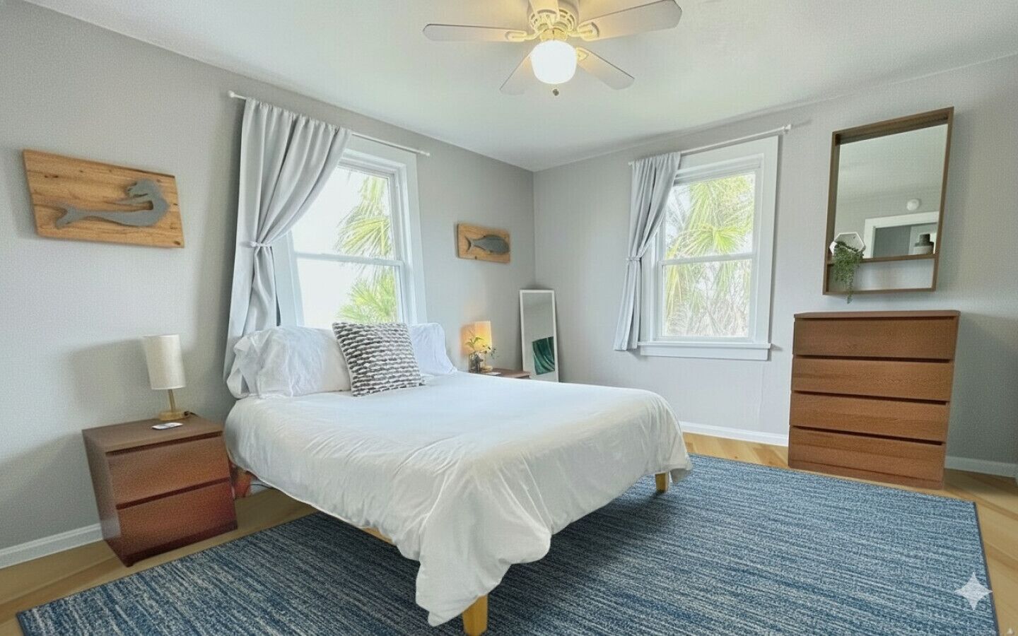 A bedroom with a bed, nightstand, dresser, and a ceiling fan.