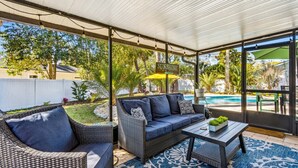 Un espace extérieur aménagé en terrasse, avec des meubles en osier, une piscine et un panneau indiquant « SOLEIL ».