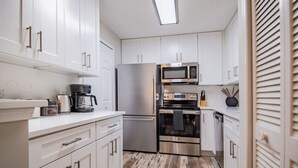 A kitchen with white cabinets, stainless steel appliances, and a wooden floor. - NEW! Coastal Haven: beach, bikes, near Mayo, golf (Ponte Vedra Beach)