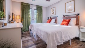 A bedroom with two beds, a ceiling fan, a desk, and a window with curtains. - NEW! Coastal Haven: beach, bikes, near Mayo, golf (Ponte Vedra Beach)