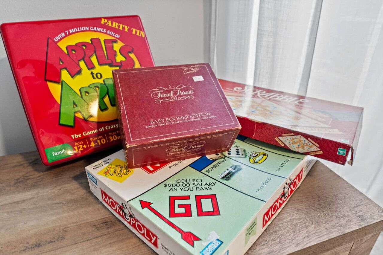 A Monopoly board game, a red box labeled 'Baby Boomer Edition,' and a 'Party Tin' with 'Apples to Apples' game.