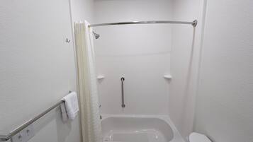 Um banheiro pequeno e branco, com banheira, vaso sanitário e cortina de chuveiro.
