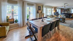 Un salón amplio con comedor, ventanas grandes y una chimenea.