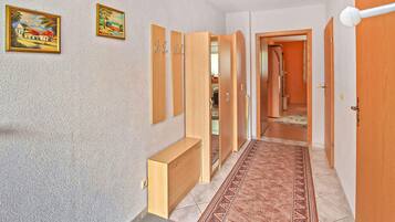 Ein Flur mit einer Bank, einem Holzschrank und zwei Bildern an der Wand.