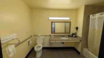 A bathroom with a toilet, sink, mirror, and shower curtain.
