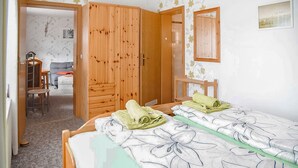 A bedroom with two beds, a wooden wardrobe, a desk, and a chair. - Ferienwohnung Brotterode (Brotterode-Trusetal)