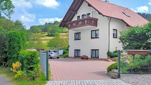 A two-story building with a red-tiled roof and a balcony. - Ferienwohnung Brotterode (Brotterode-Trusetal)