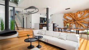 Relax in this open-plan living space with a large sofa, sleek coffee table, and unique wall art.