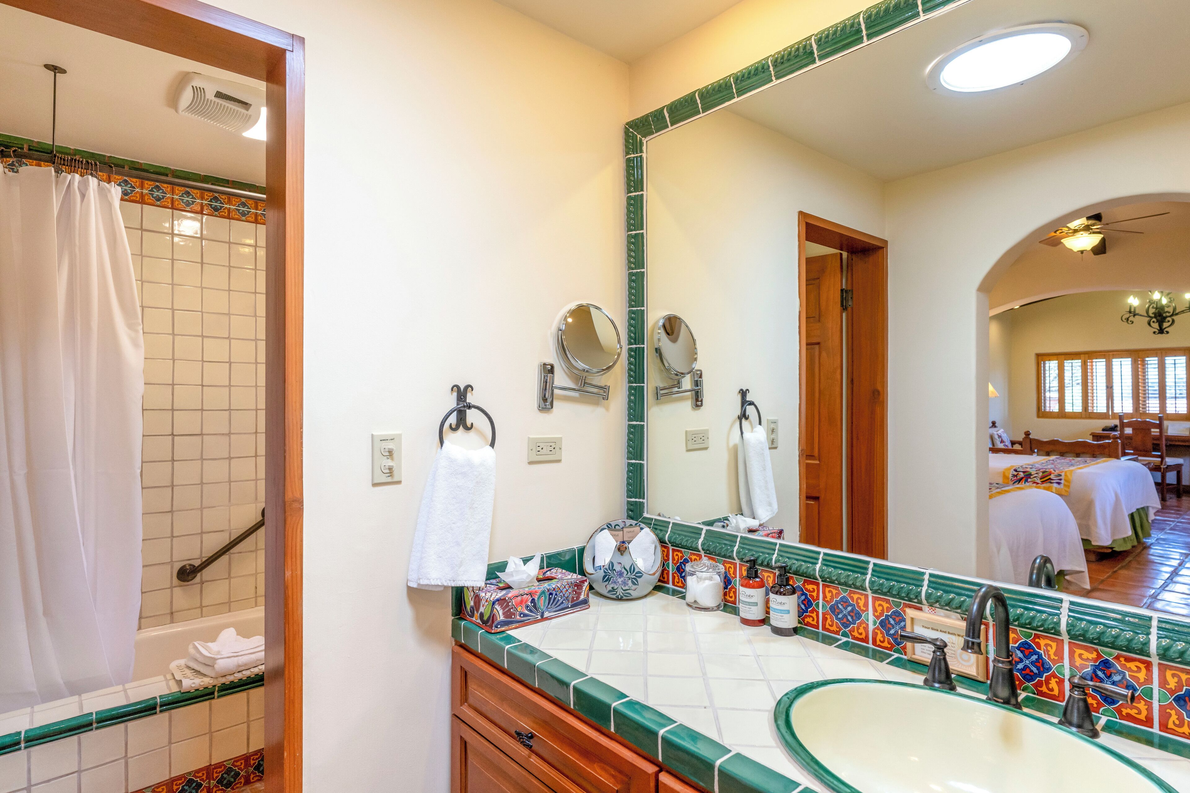 Un baño con un espejo grande, un lavabo y una zona de ducha.