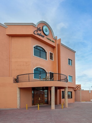A hotel with a prominent sign, a balcony with seating, and a large entrance door. - Los Cedros Hotel Inn Ciudad Juárez (Ciudad Juárez)