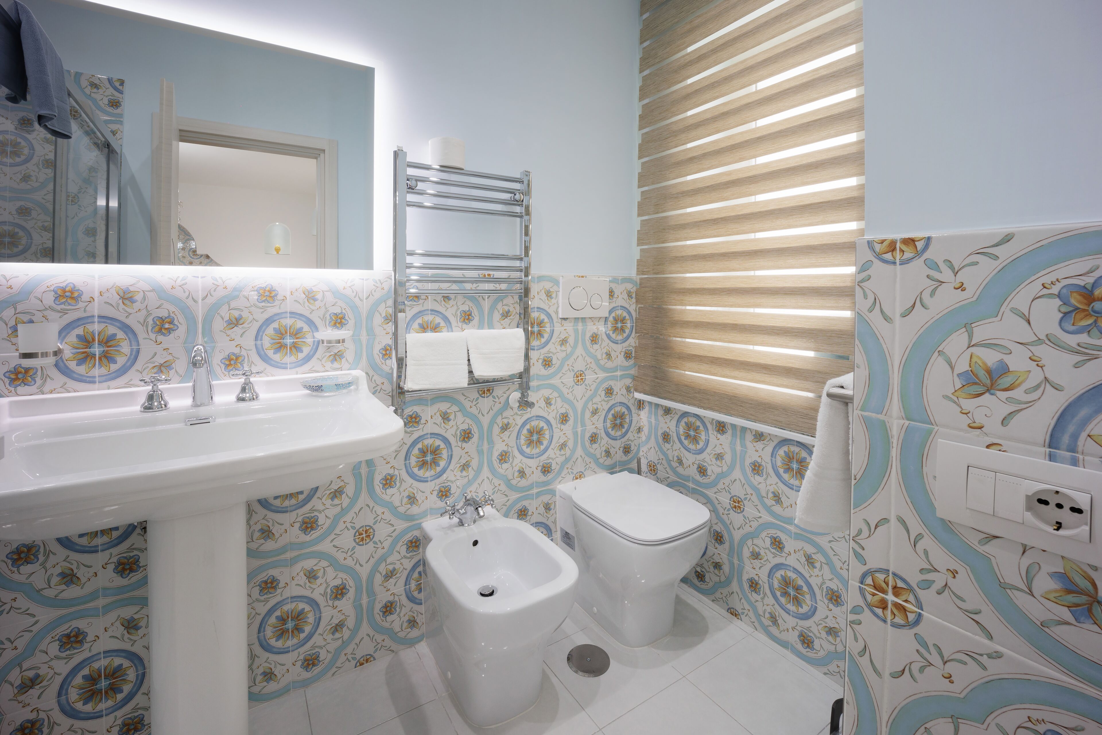 Une salle de bain équipée d’un lavabo, d’un bidet, de toilettes et d’un porte-serviettes.