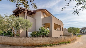 A modern two-story house with a flat roof, large windows, and a stone retaining wall. - Beach front apartment in Vir with WiFi (Vir)