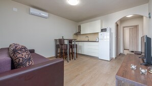 A compact living space with a kitchenette, a dining area, and a seating area with a sofa and chairs. - Beach front apartment in Vir with WiFi (Vir)