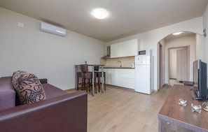 A compact living space with a kitchenette, a dining area, and a seating area with a sofa and chairs. - Beach front apartment in Vir with WiFi (Vir)