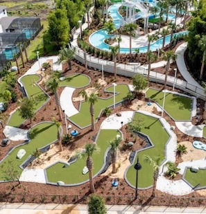A golf course with multiple holes, a central water feature, and a surrounding landscaped area.