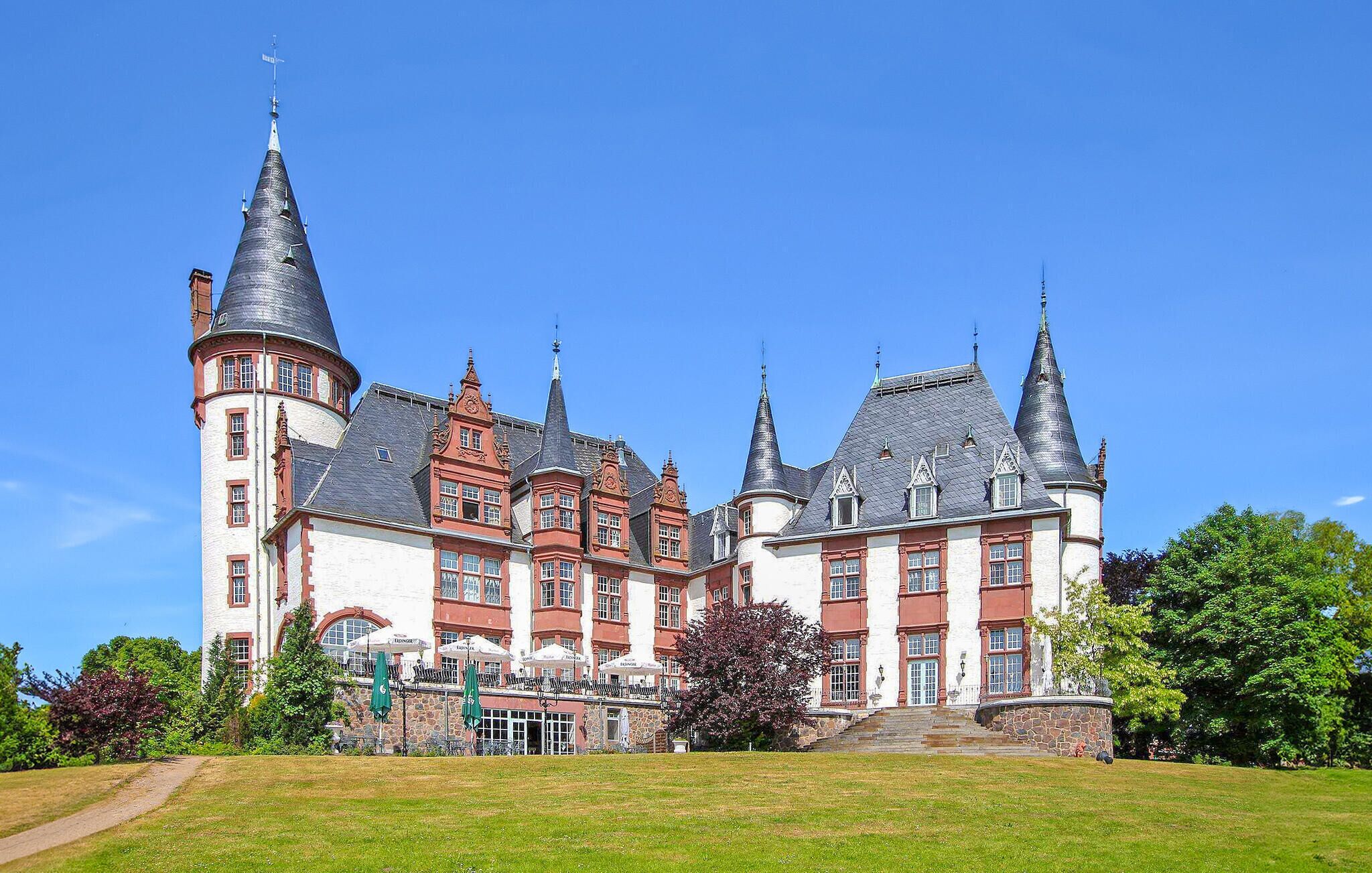 Un grand bâtiment historique doté de nombreuses tours et d’une cour intérieure.