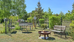 A fenced outdoor area with a picnic table, benches, and a fire pit. - 2 bedroom lovely apartment in Mirow (Mirow)
