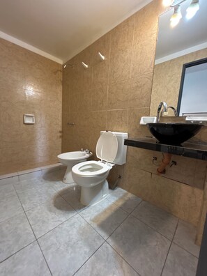 A bathroom with two toilets, a sink, and a mirror. - Santa Fe Suites (Buenos Aires)