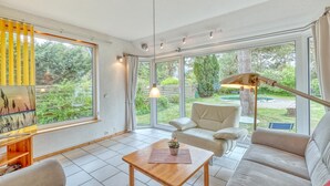A modern living room with a large window, a sofa, a coffee table, and a lamp. - Ferienwohnung Pruchten (Pruchten)