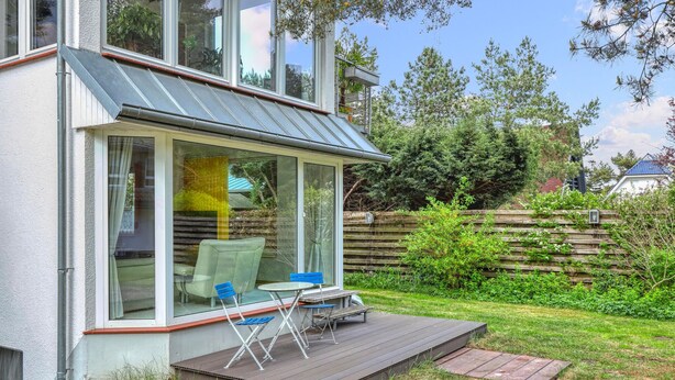 A modern house with a glass door leading to a patio area with a table and chairs. - Ferienwohnung Pruchten (Pruchten)