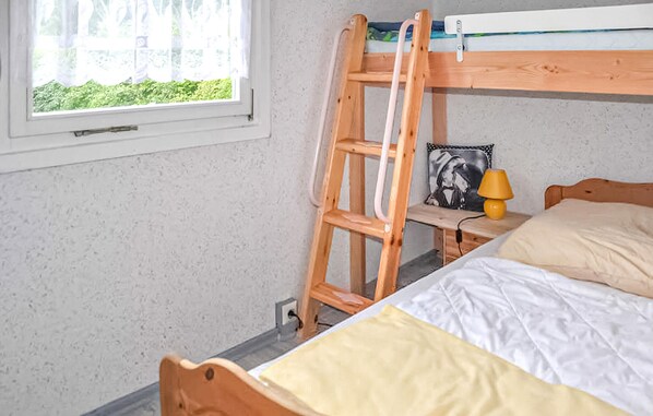 A bedroom with a bunk bed, a wooden ladder, a bedside table with a lamp, and a window with a view of greenery. - 2 bedroom awesome home in Wesenberg (Wesenberg)