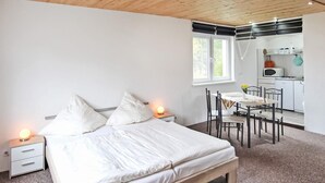 Un dormitorio con cama, mesitas de noche, un escritorio y una silla.