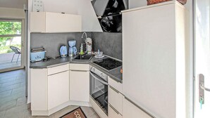 Cuina compacta amb fogó, rentatallopes i cafetera.