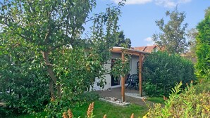 A house with a garden, a pergola, and a patio area. - Ferienwohnung Kölpinsee/Usedom (Kölpinsee/Usedom)