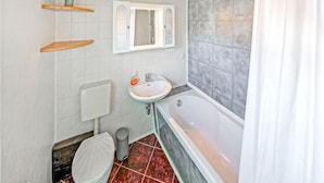 A bathroom with a toilet, sink, and bathtub.