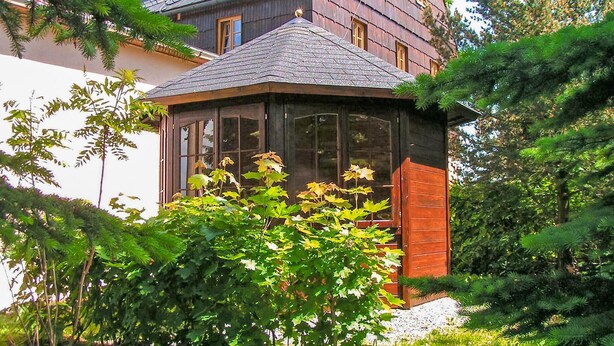 A traditional wooden house with a gabled roof and a glass conservatory. - Ferienwohnung Neuhausen (Neuhausen/Erzgeb.)