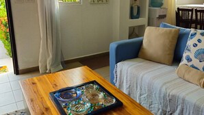 Un salon chaleureux avec une table basse en bois, un canapé bleu et une fenêtre avec des rideaux.