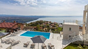 Une piscine sur le toit offrant une vue sur un lac et les bâtiments environnants.