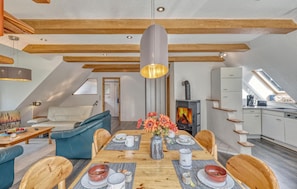 Un espace moderne de style « loft », comprenant un coin repas, un canapé et une cuisine.