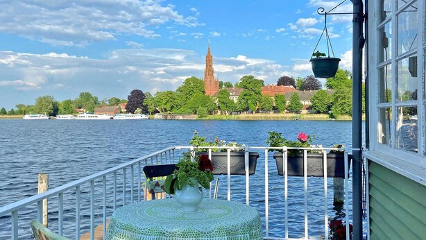 A balcony with a view of a river, a church, and boats. - 1 bedroom awesome home in Malchow (Malchow)