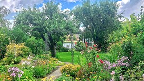 A garden with a variety of flowers and a central archway. - 1 bedroom awesome home in Malchow (Malchow)