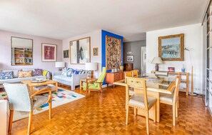 Amplia sala de estar con sofá, sillones, una mesa de centro y una estantería.