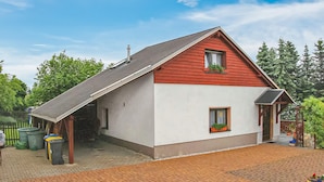 A single-story house with a sloped roof, a small porch, and a brick driveway. - Ferienhaus Bärenstein (Bärenstein)