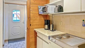 Eine kleine Küche mit Mikrowelle, Toaster, Kaffeemaschine und Herd.