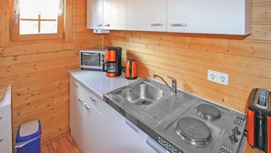 A compact kitchen with a sink, a toaster, a coffee maker, and a microwave.